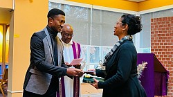 Fr. Darlington Oparaike, CSSp presents Beverly Bronte-Tinkew with the Spiritan Rule of Life, December 11,2023